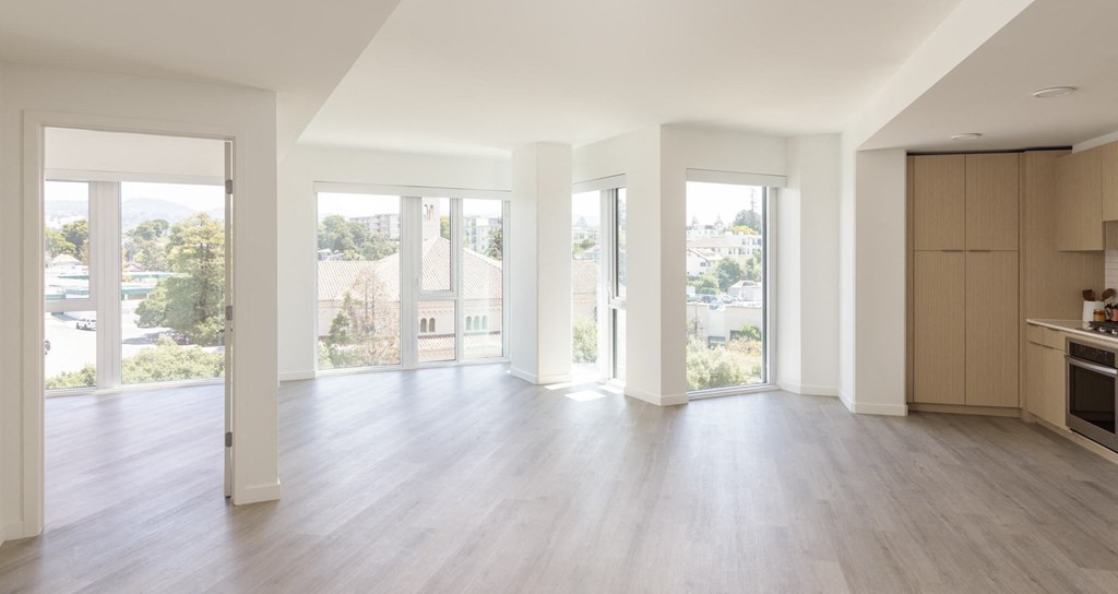 an empty living room with white walls and wood floors