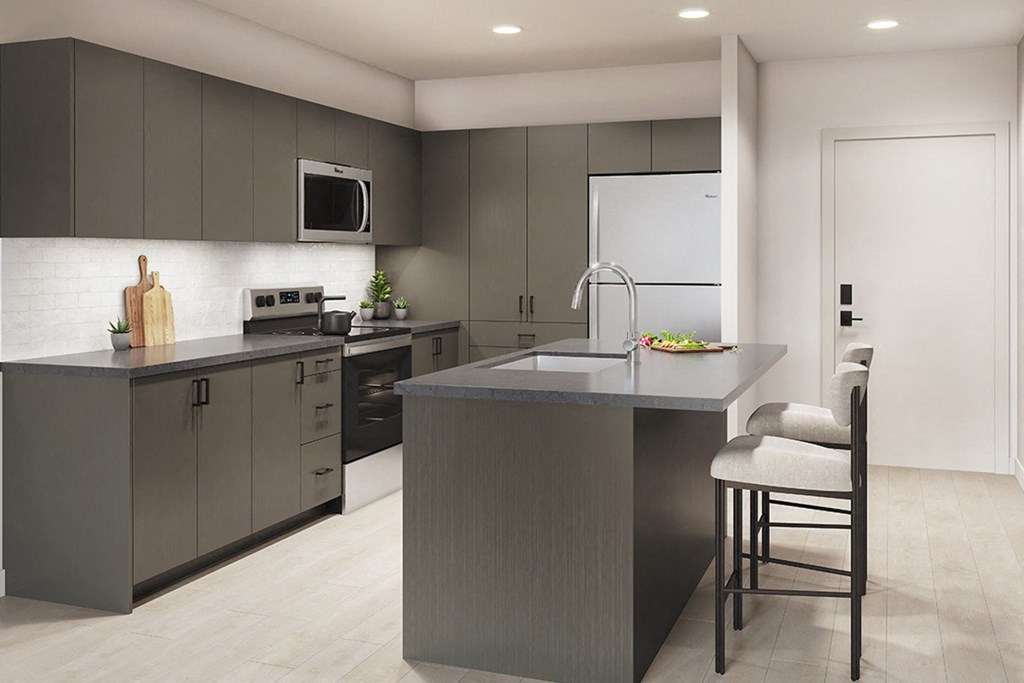 a kitchen with gray cabinets and a large island with two chairs