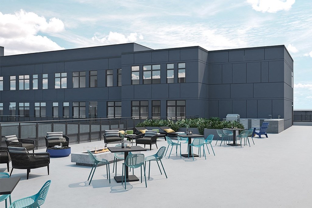 a patio with tables and chairs on the roof of a building