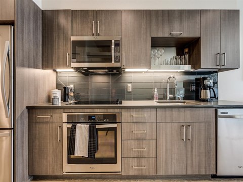 A modern kitchen with wooden cabinets and stainless steel appliances.