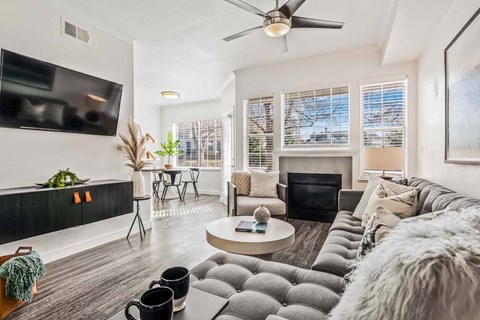A living room with a grey couch and a black coffee table.