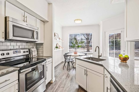A modern kitchen with a stainless steel oven and microwave.