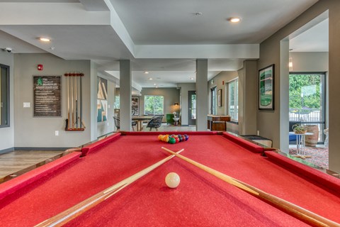 A pool table with a white ball in the middle of it.