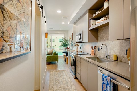 A kitchen with a green chair and a painting on the wall.
