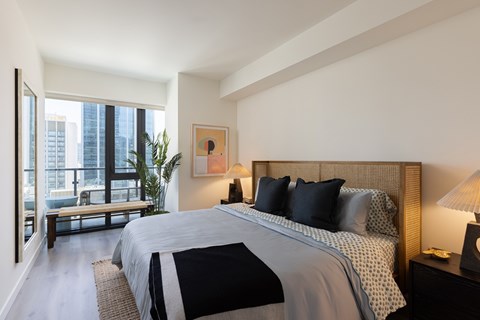 A bedroom with a large bed and a view of the city.