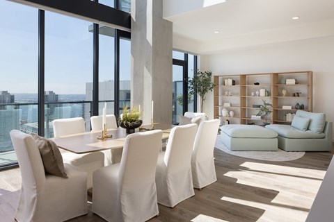 A modern dining room with white chairs and a table.