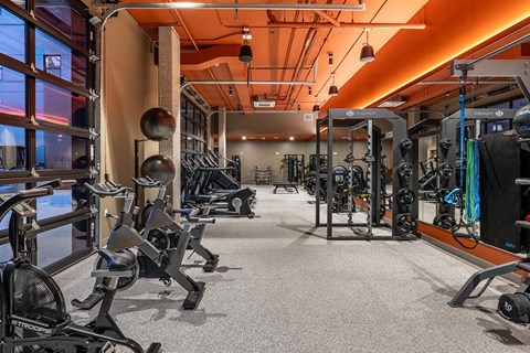 A gym with a variety of equipment including weights and cardio machines.