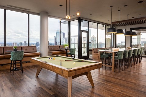 A pool table in a room with a view of the city.