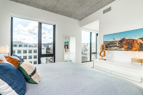 A bedroom with a large bed and a painting of a cow on the wall.