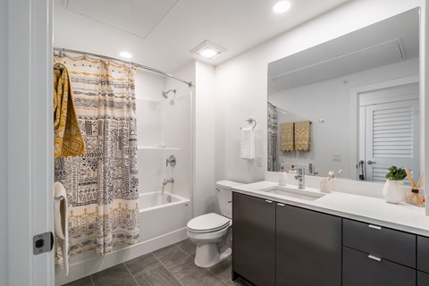 A bathroom with a toilet, sink, and shower.