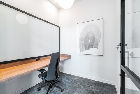A black chair is in front of a glass wall.