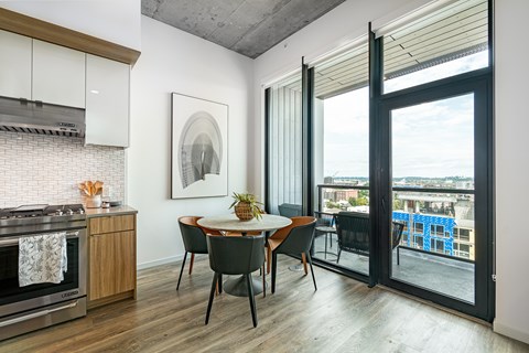 A modern kitchen with a dining table and chairs.