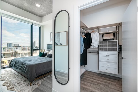 A bedroom with a large bed and a walk-in closet.