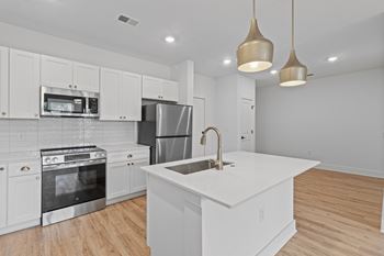 A kitchen with white cabinets and a stainless steel refrigerator.
