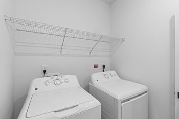 Two white front loading washing machines in a laundry room.
