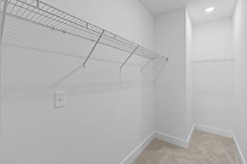 Empty room with a wire shelving unit and a carpeted floor.