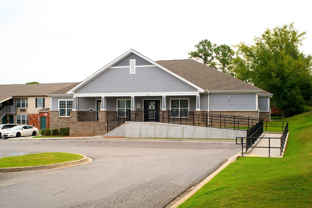 the front of a building with a ramp and a parking lot