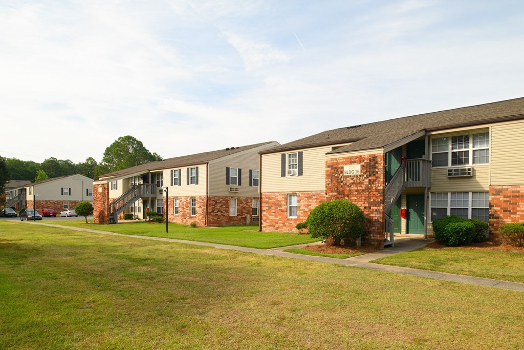 an exterior view of a row of apartment buildings on a lawn