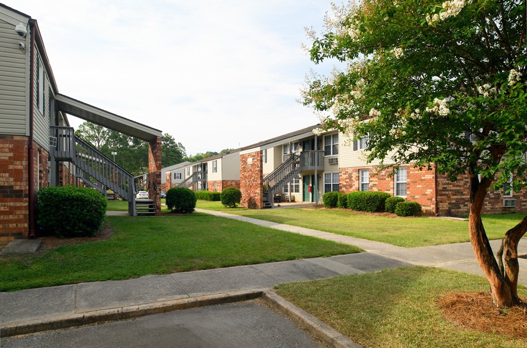 an exterior view of an apartment building with sidewalks and grass