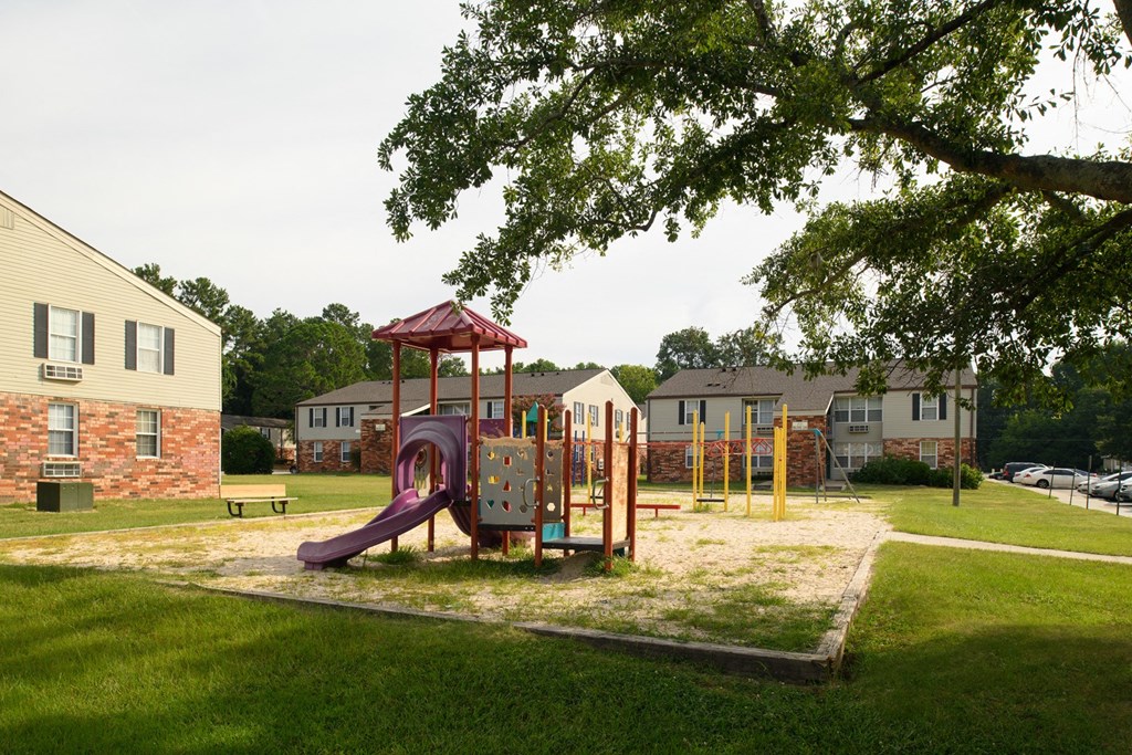 a playground in a park with houses in the background