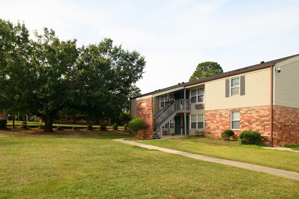 an exterior view of a church building with a lawn and trees
