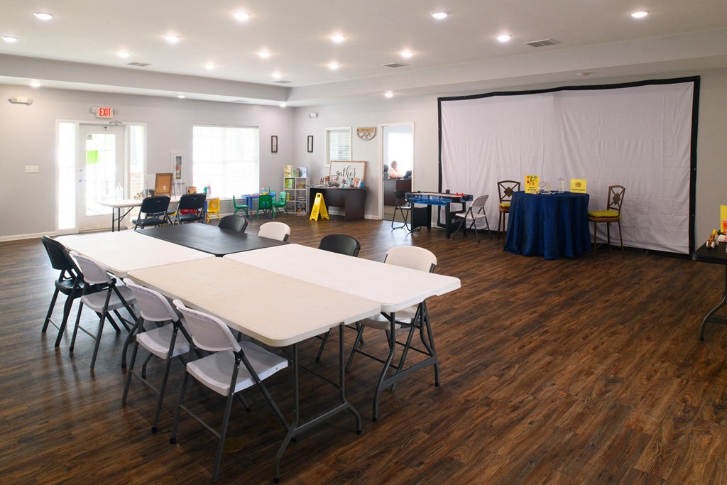 a multipurpose room with tables and chairs and a projector screen