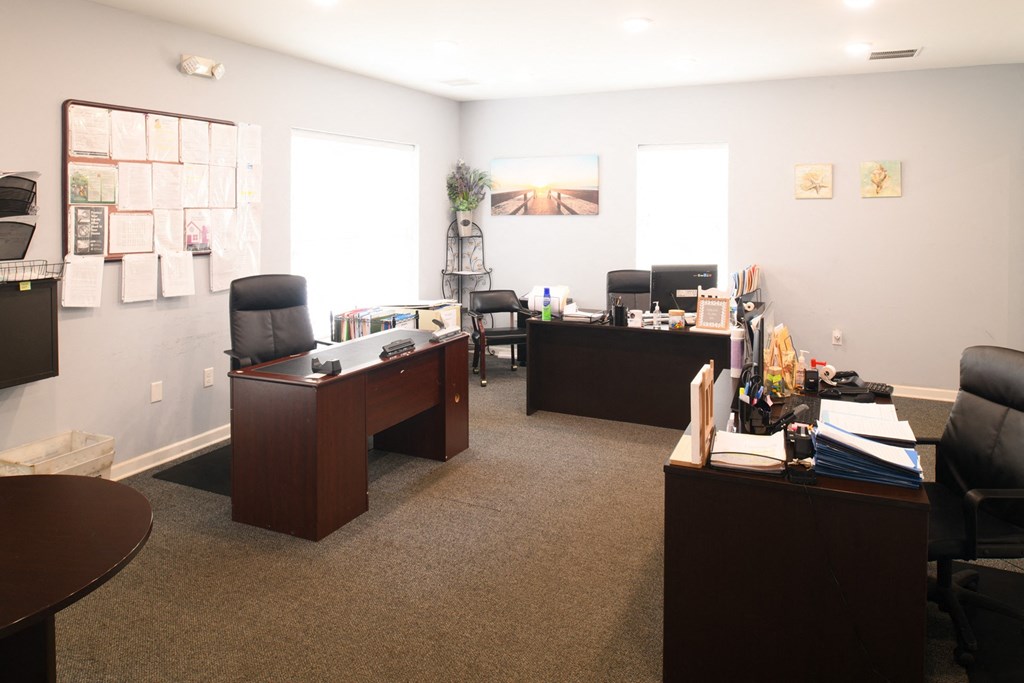 an office with two desks and chairs and a window