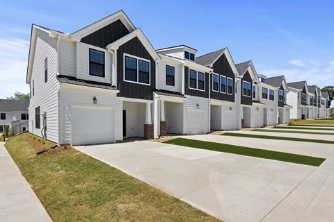 A row of houses with garages and driveways.
