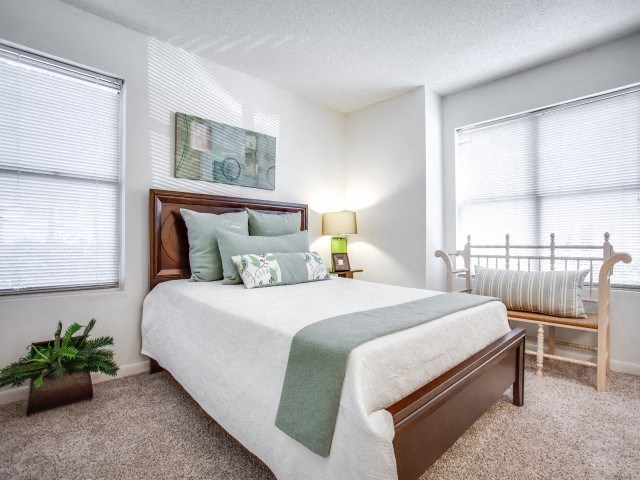 A bedroom with a large bed and a painting on the wall.