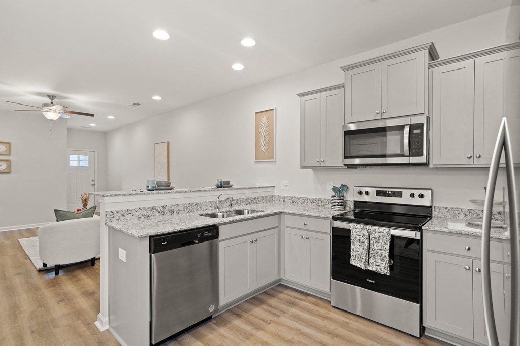 a large kitchen with white cabinets and stainless steel appliances