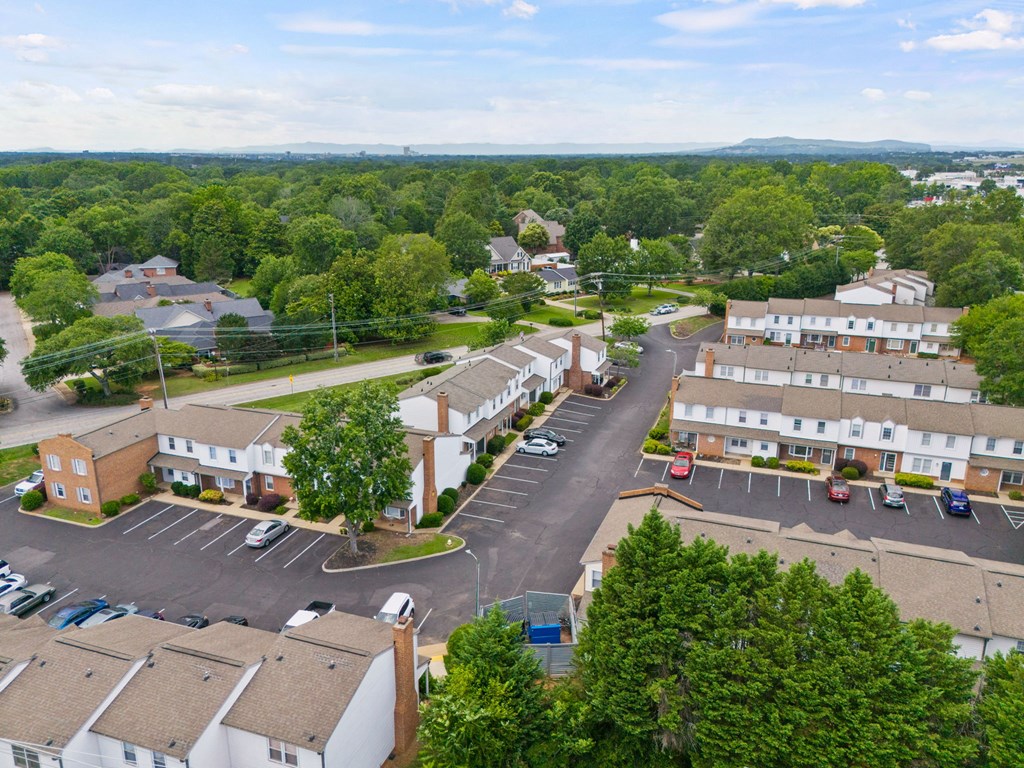 A bird's eye view of a residential area with houses and parked cars.