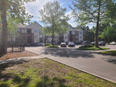 an apartment building with cars parked in a parking lot