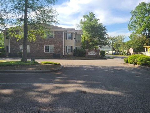 A sunny day at the entrance of a brick apartment building.