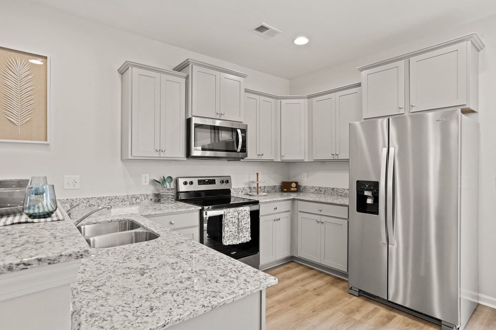 a kitchen with white cabinets and a stainless steel refrigerator