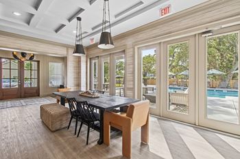 A dining room with a pool in the background.