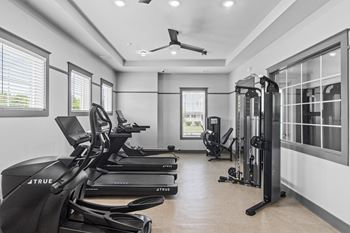 A gym with treadmills, a stationary bike, and a weight machine.