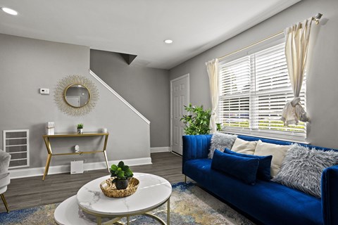 A living room with a blue couch and a white coffee table.