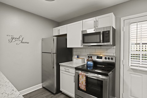 A kitchen with a wall decal that says