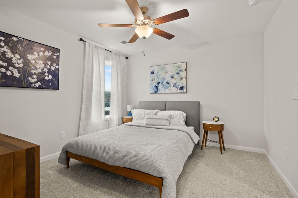 a bedroom with a bed and a ceiling fan