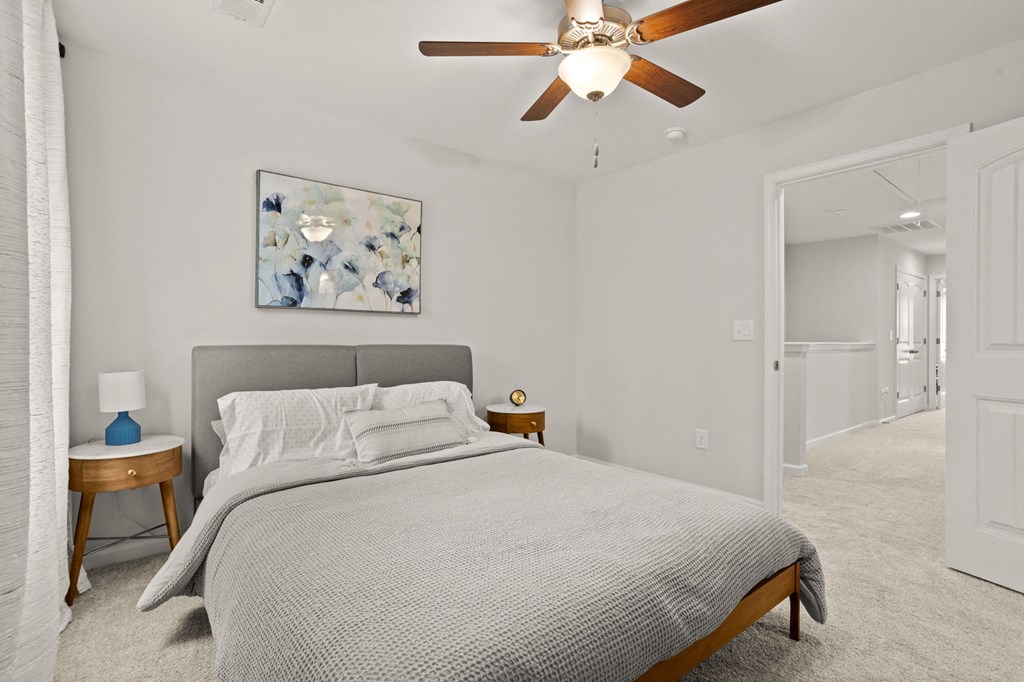 a bedroom with a large bed and a ceiling fan