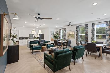 A living room with a green sofa and a ceiling fan.