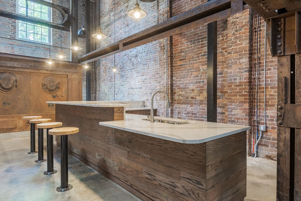 a kitchen with exposed brick walls and a bar with stools