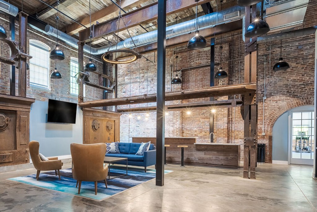 Newry Mill fully furnished rustic style lounge with two chairs, coffee table, a couch along with a television.