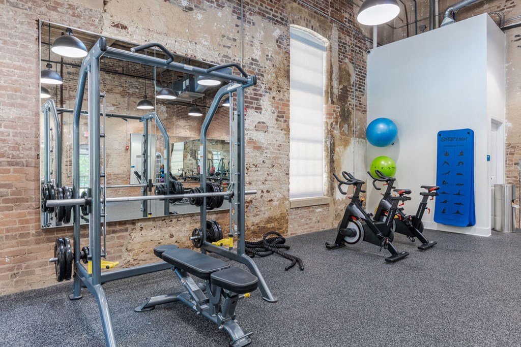 a gym with exercise equipment and weights in a loft space