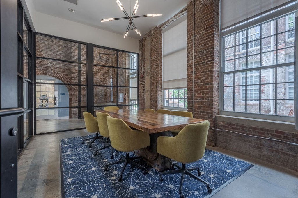 a conference room with a table and chairs and a brick wall