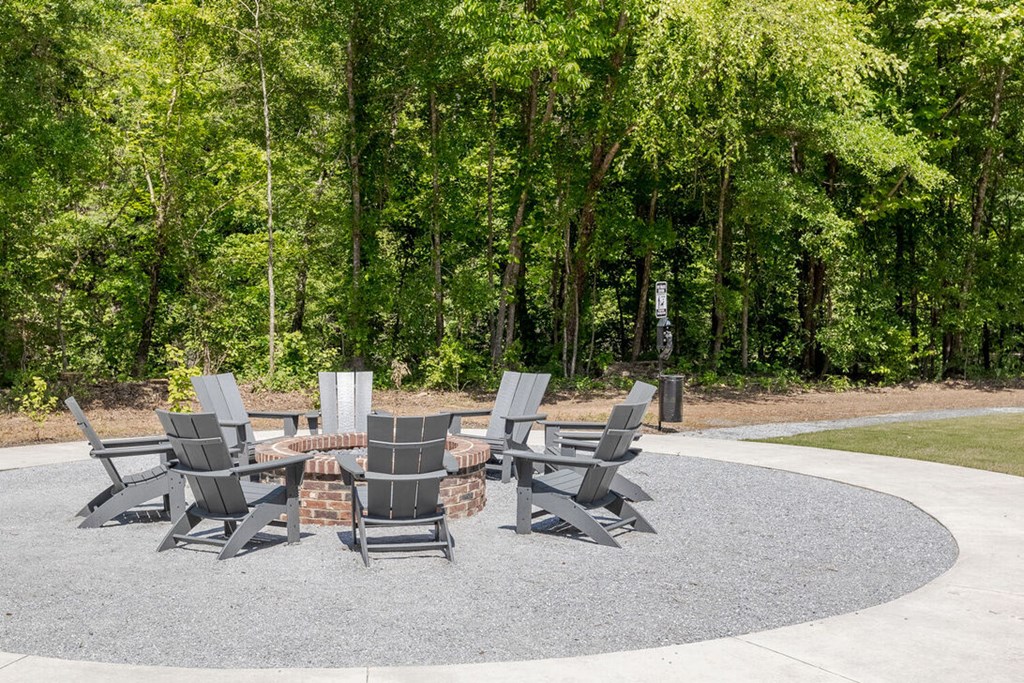 a group of chairs around a table in a park