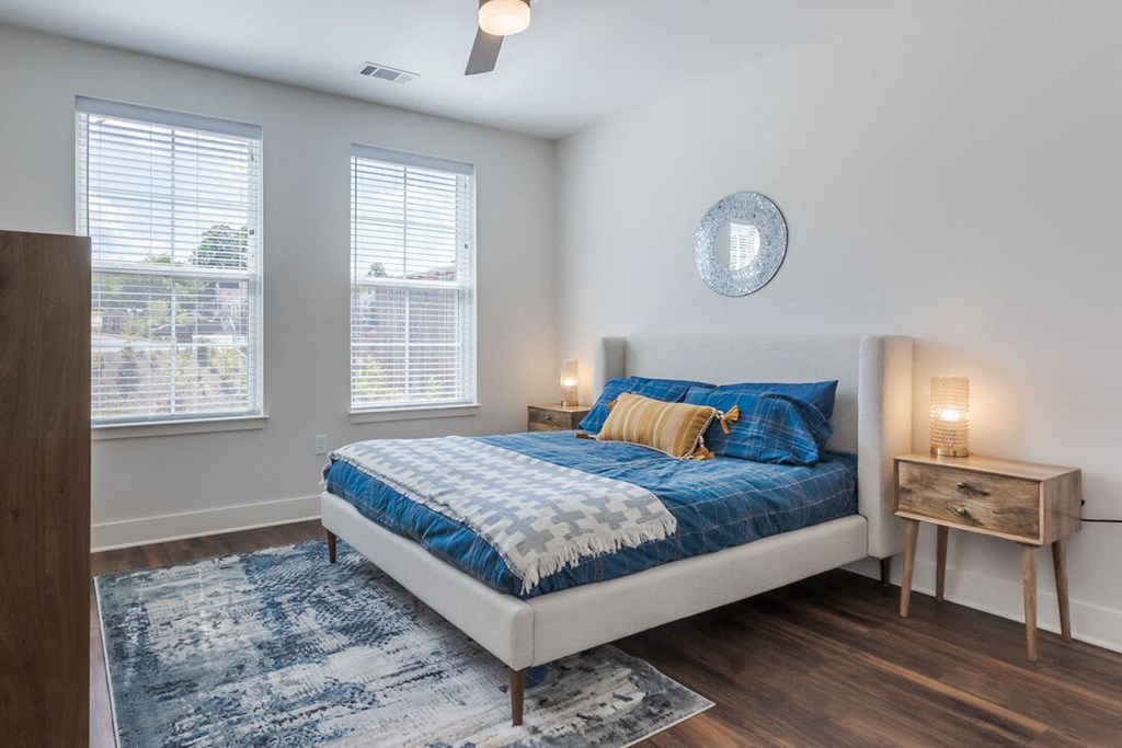 a bedroom with a bed and two windows