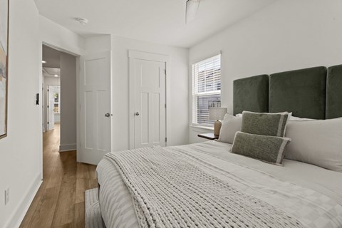 A bedroom with a large bed and a window.