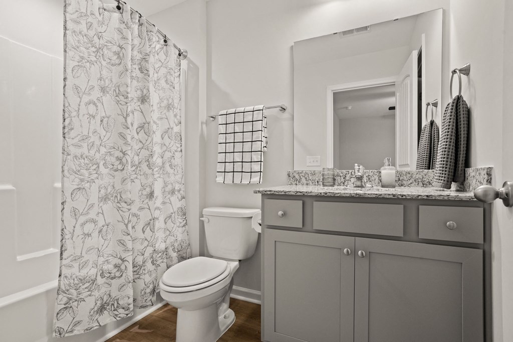 a bathroom with a shower and a toilet and a sink