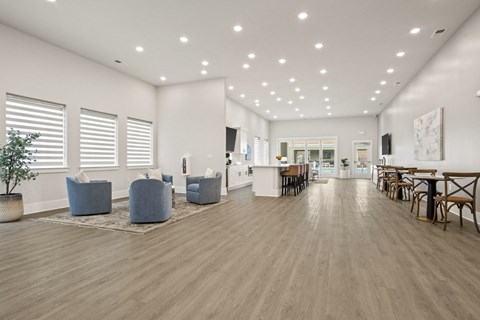 A spacious room with wooden floors and furniture.